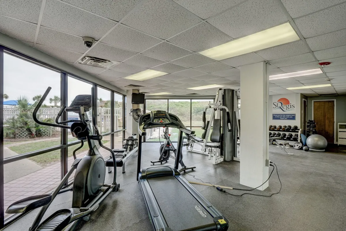 A spacious, light-filled fitness center with treadmills, ellipticals, weight machines, and large windows offering scenic outdoor views. The area looks modern, clean, and motivating for guests interested in health and wellness.